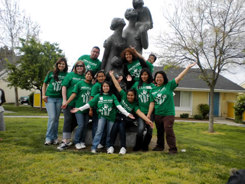 student volunteers posing by statue
