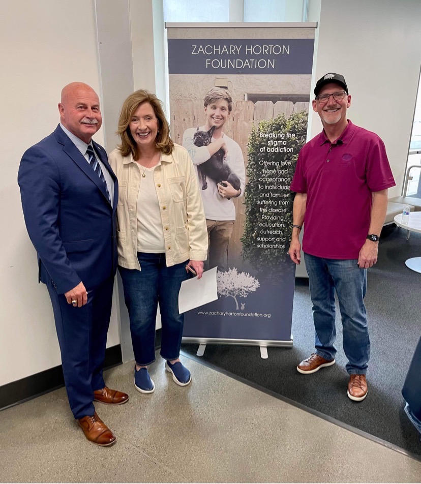 Image of three people standing by zachary horton sign