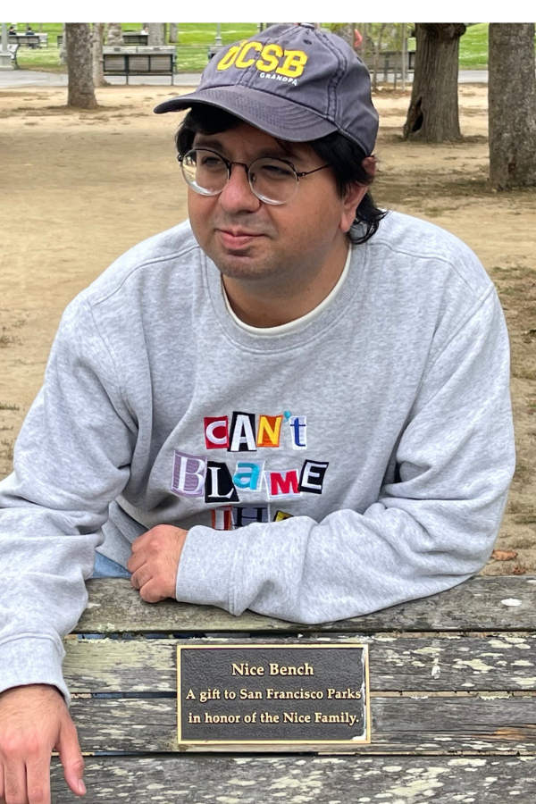 photo of Indigo standing behind a park bench
