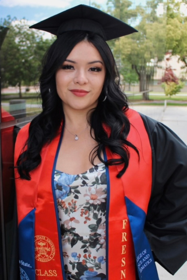 Mona standing outside in her graduation regalia