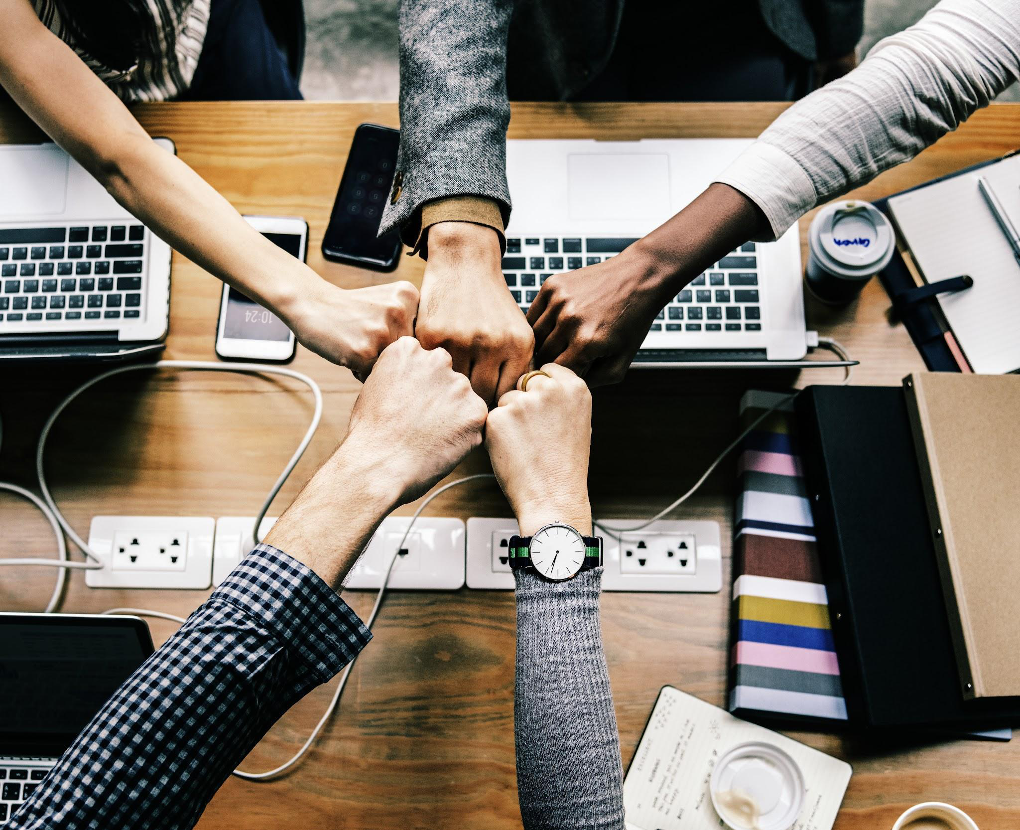 Close-up teamwork image showing hands stacked together