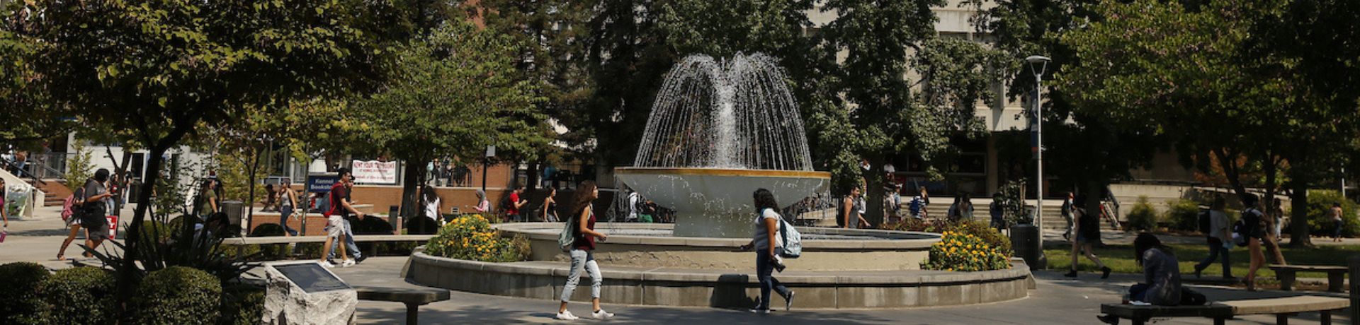 Students walking in front of the Fresno State fountain