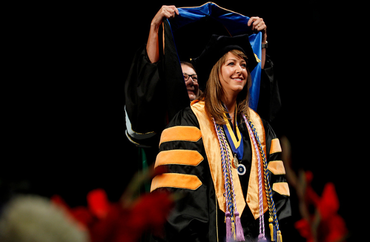 female doctoral student being hooded at graduation
