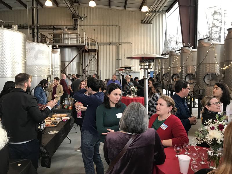 a gathering of 40ish faculty in the Fresno State Winery at a mixer event