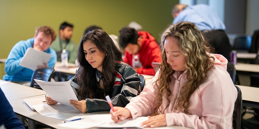 Students taking and reading over notes in a classroom