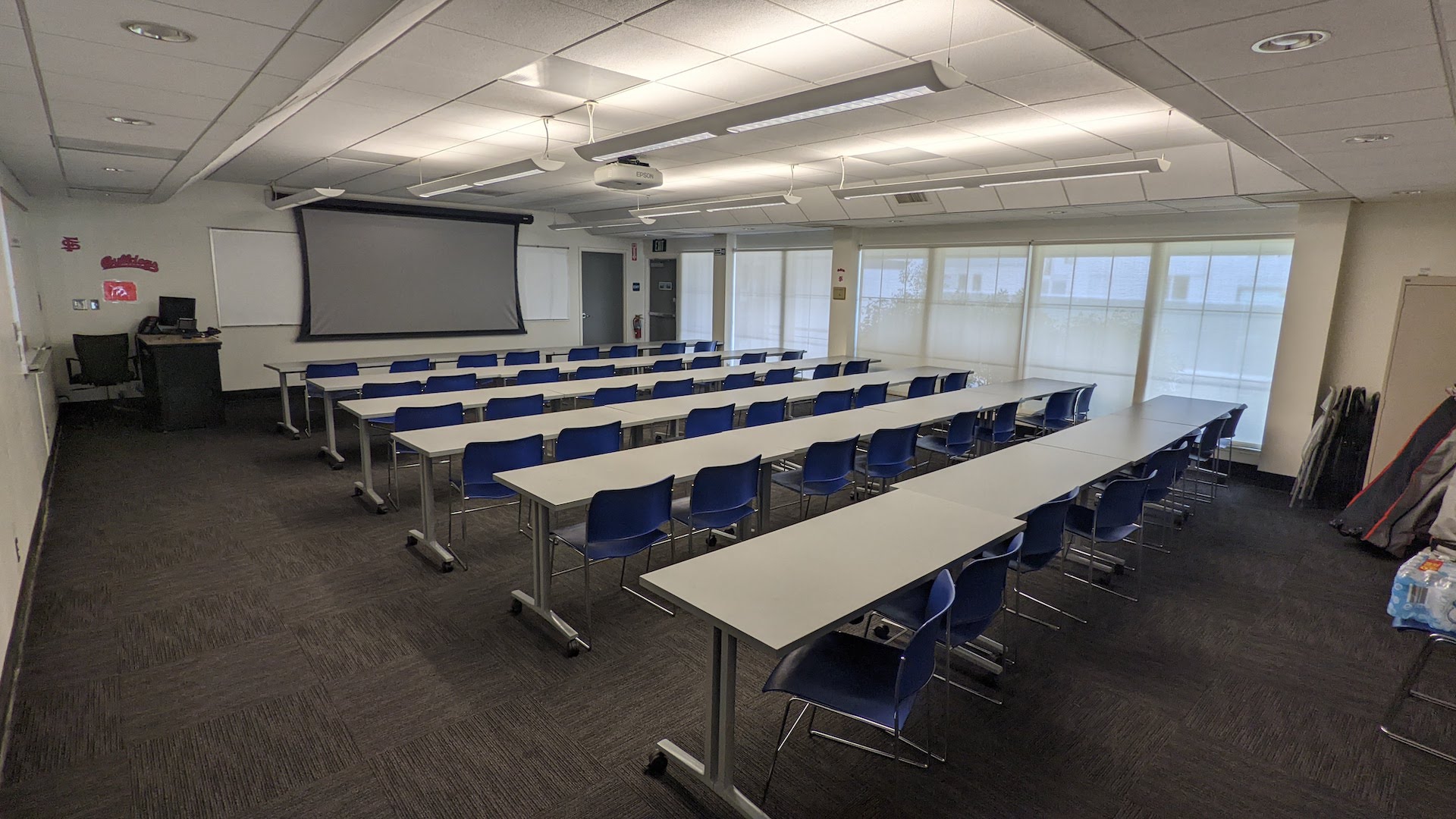 a large classroom with rows of seats and large windows on one side