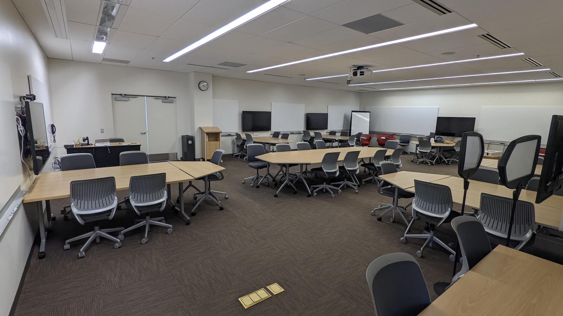 large meeting space with a conference table in the center and standalone meeting tables around the perimeter
